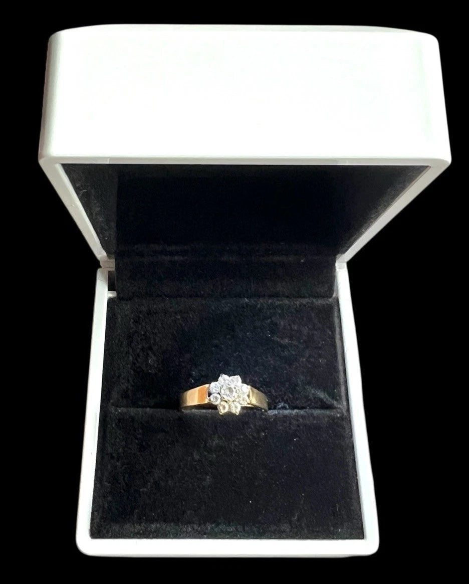 Vintage Gold ring with a cubic zirconia flower cluster in a black jewellery box on a white background