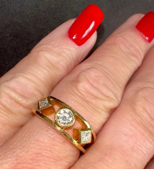 Gold ring with a diamond on a hand with red nail polish.