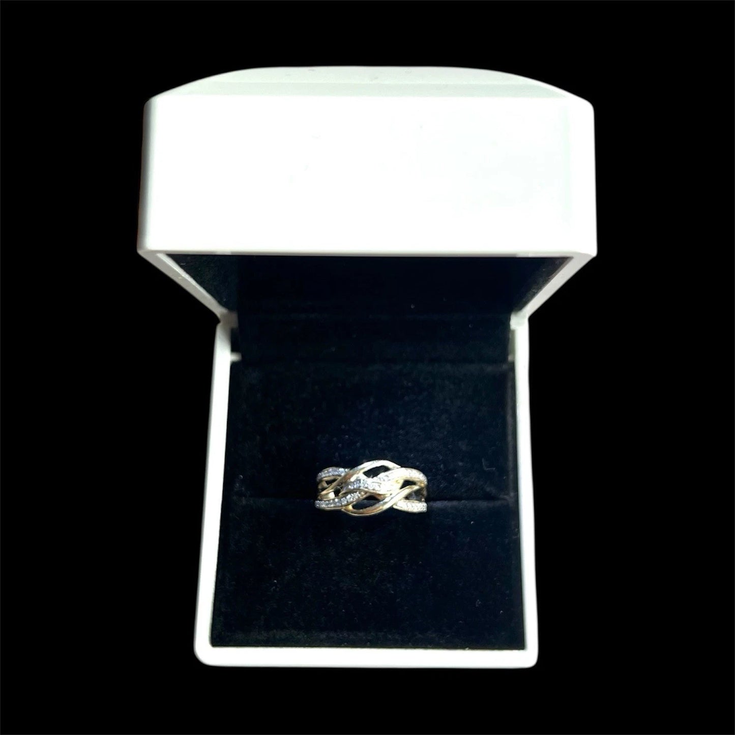 Gold diamond ring in a white box with a black interior