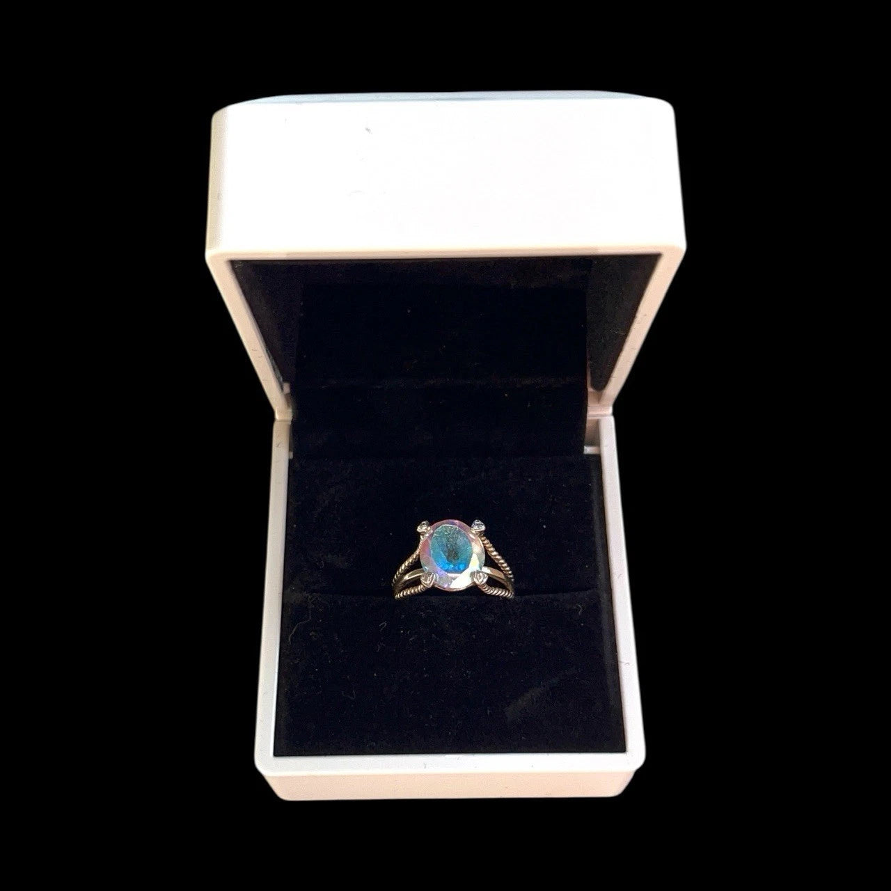 Ring with a large mystic quartz gemstone in a white box on a black background
