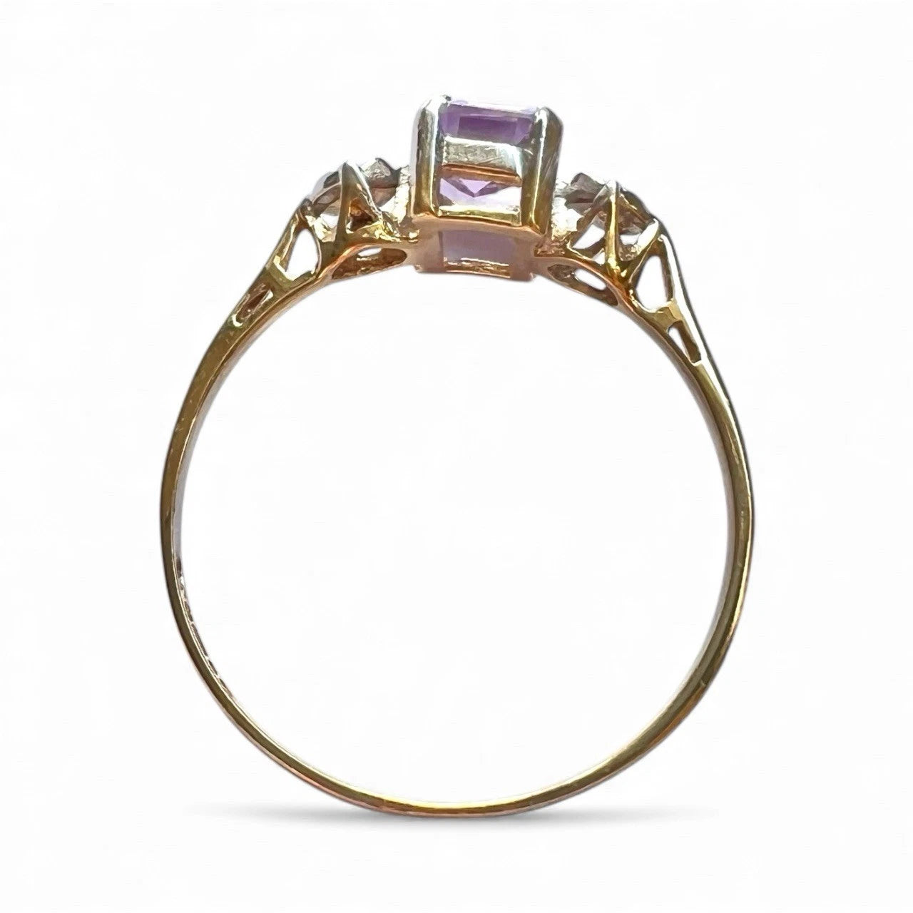 Gold ring with a purple gemstone on a white background