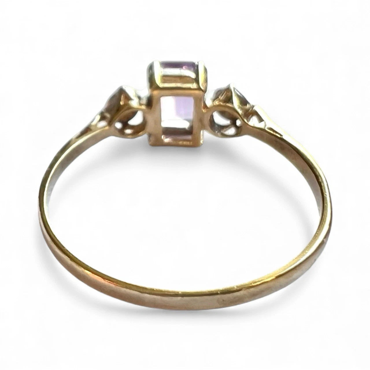 Gold ring with a central gemstone on a white background. Close up Rear view of setting and gold band 