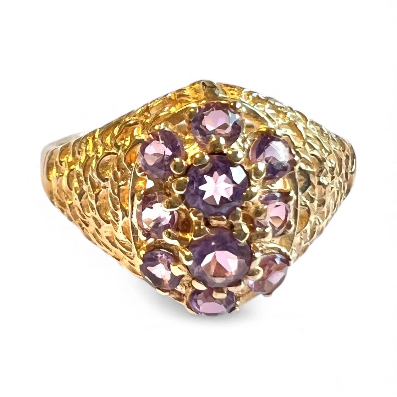 Gold ring with purple amethyst gemstones on a white background