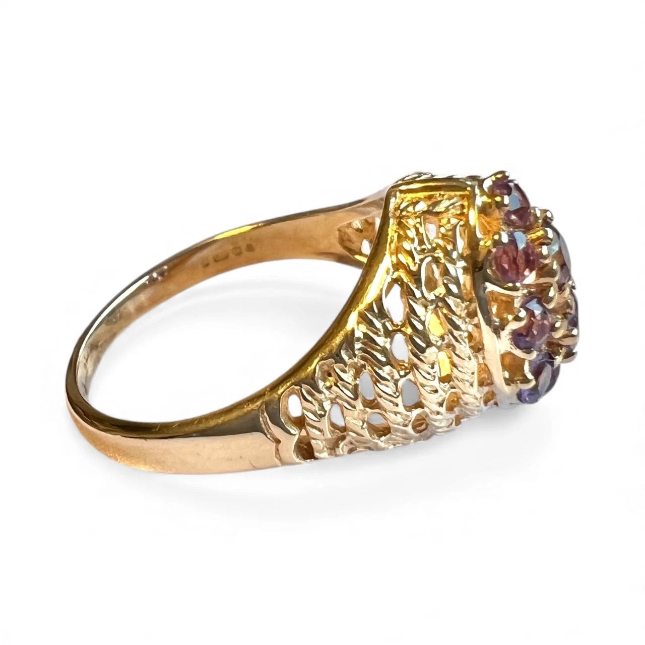 Gold ring with amethyst gemstones on a white background