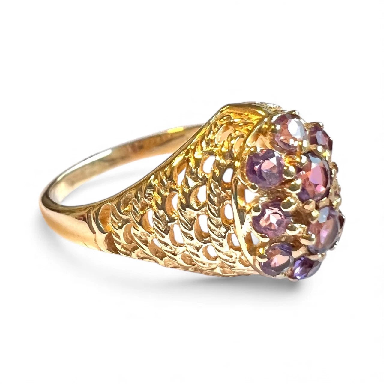 Gold ring with purple amethyst gemstones on a white background
