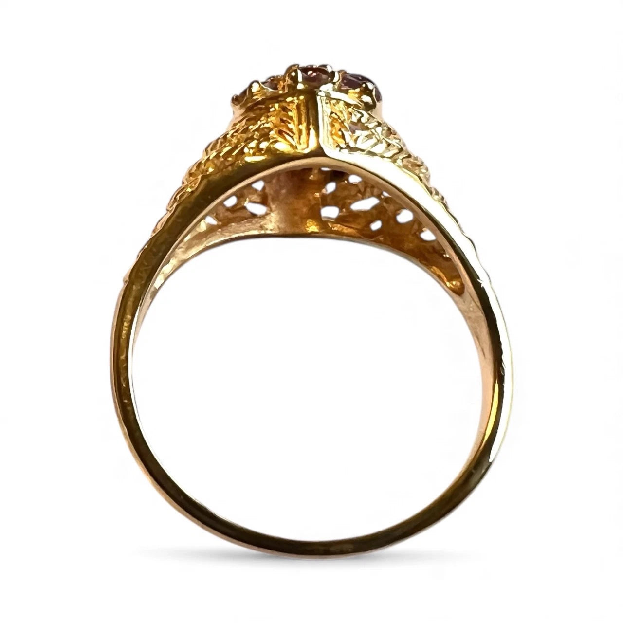 Gold ring with intricate design on a white background