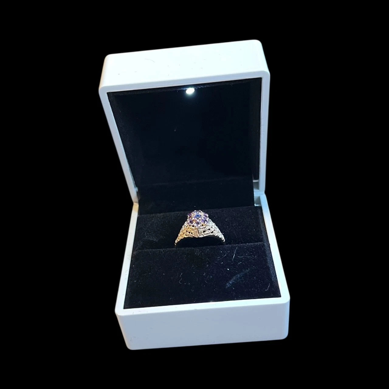 Amethyst Gold ring with gemstones in a white box on a black background