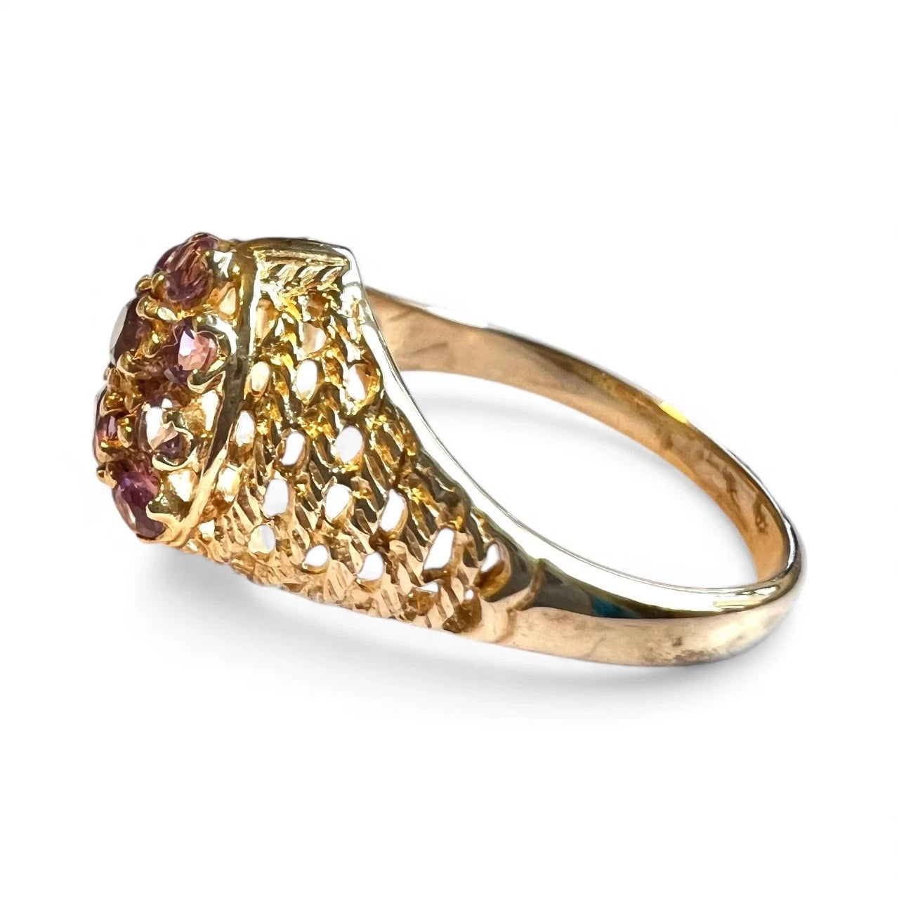 Gold ring with gemstones on a white background with textured band 