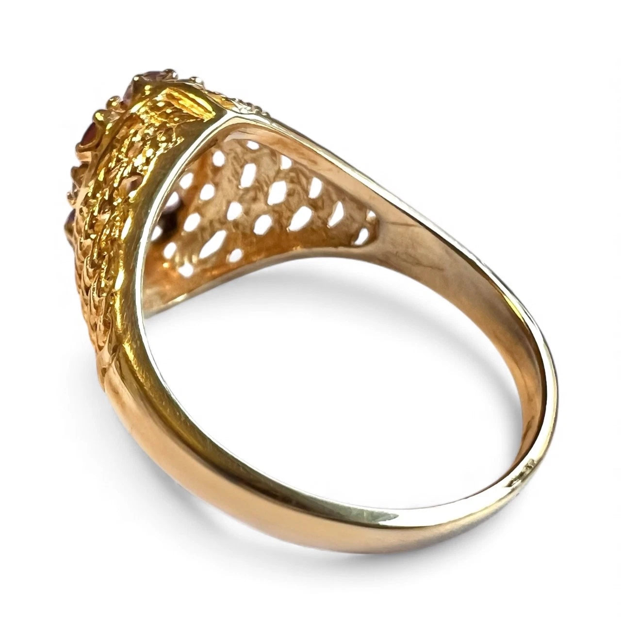 Gold ring with intricate design on a white background