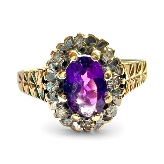Gold ring with a purple gemstone and smaller diamonds on a white background