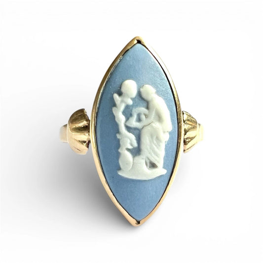 Ring with a blue stone featuring a white cameo design on a white background