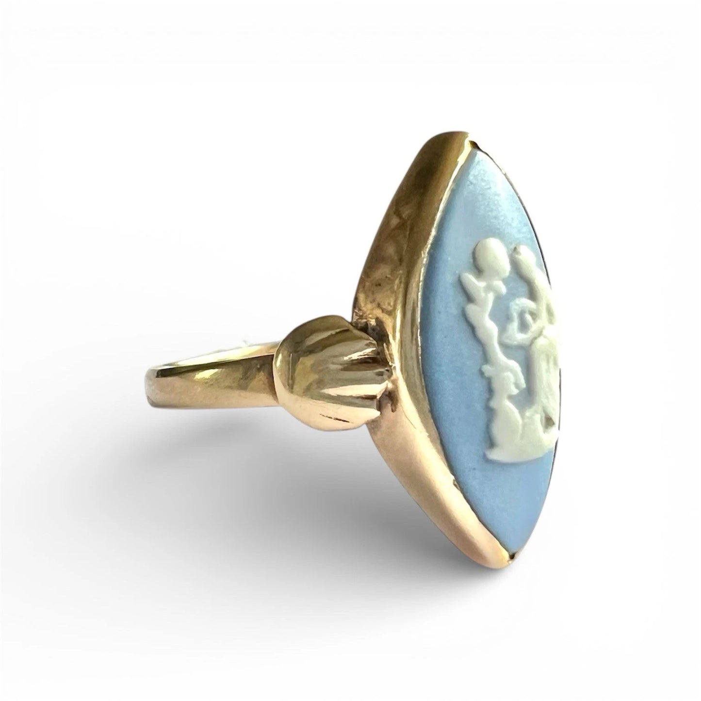 Gold ring with a blue cameo and white figure on a white background