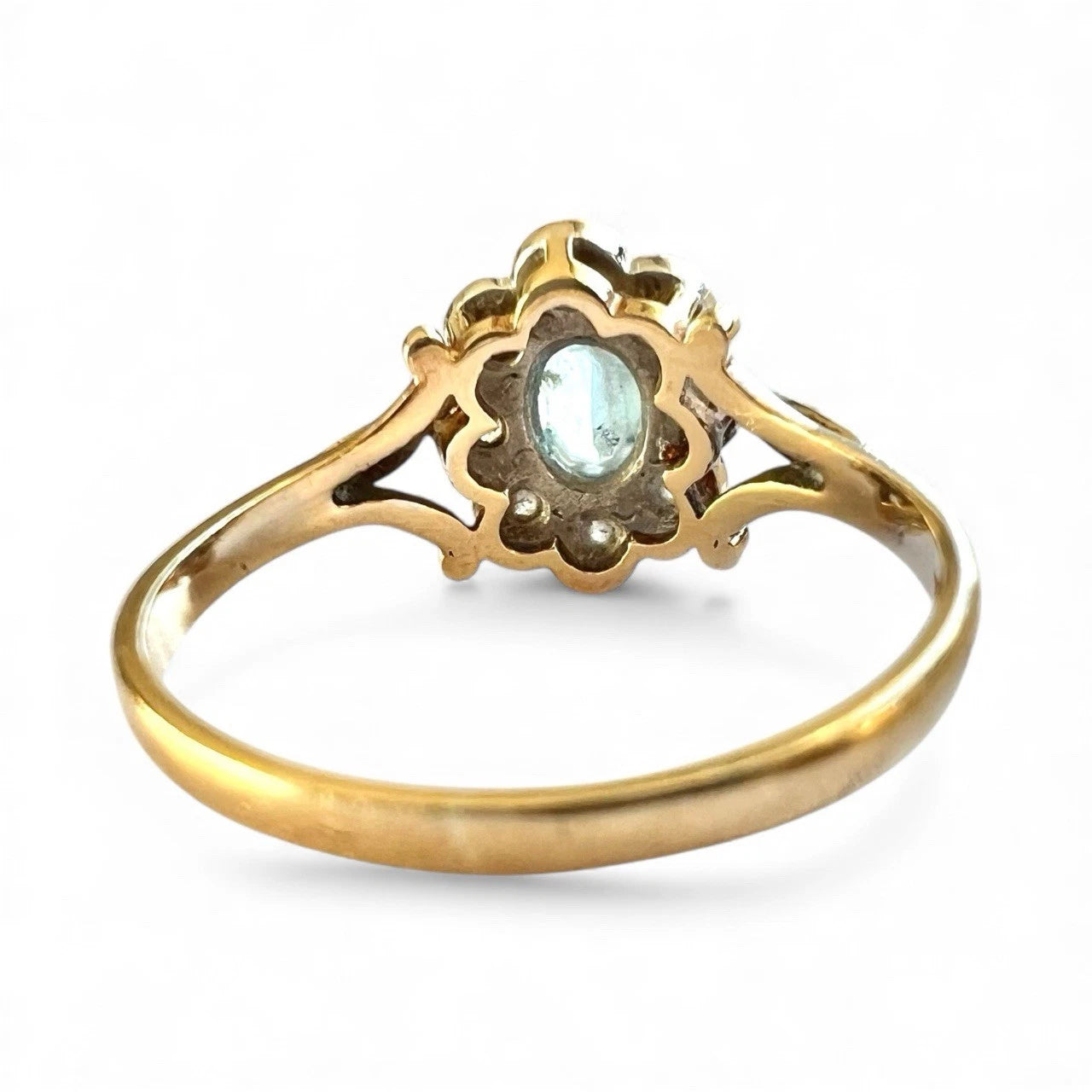 Gold ring with a central gemstone on a white background