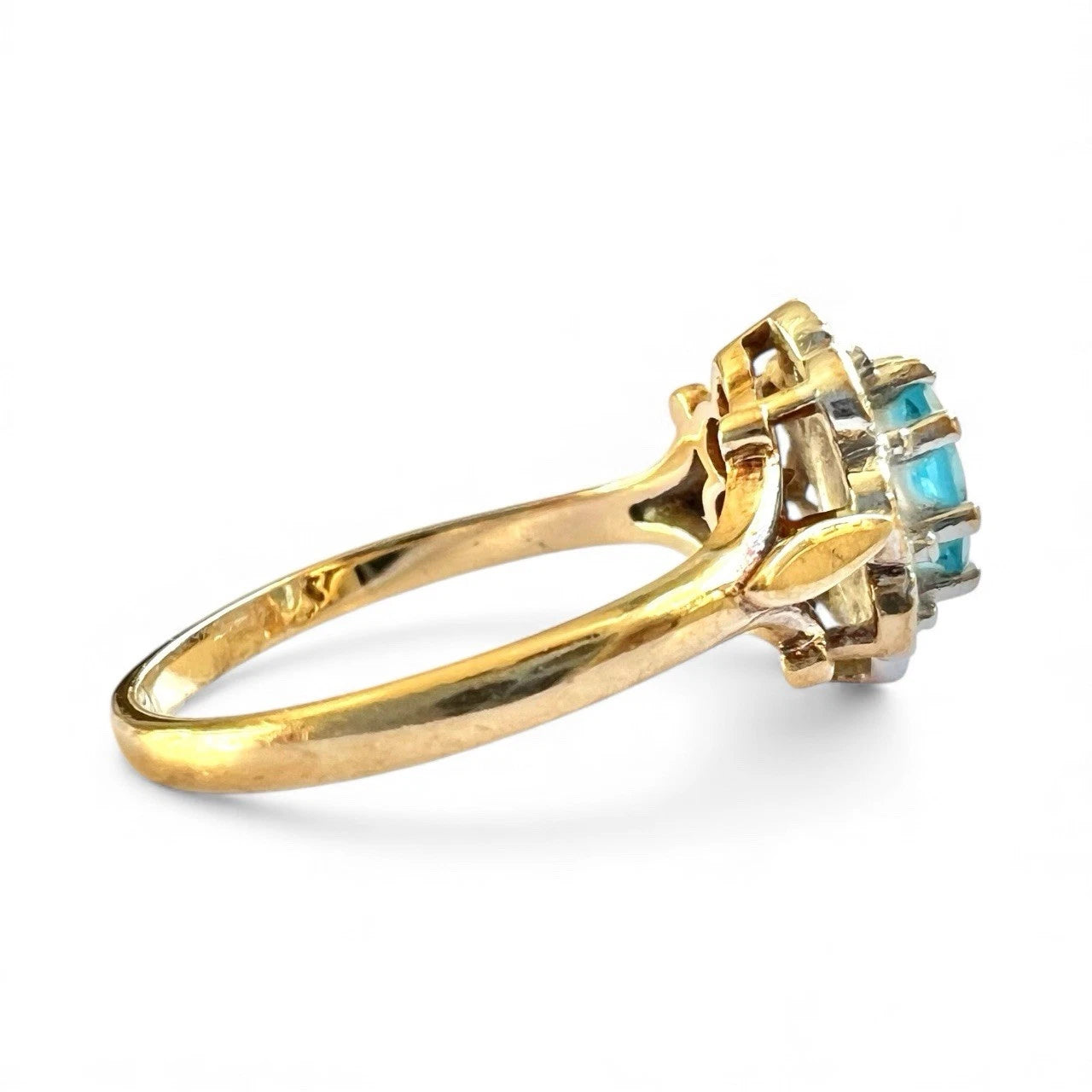 Gold ring with blue topaz gemstones on a white background