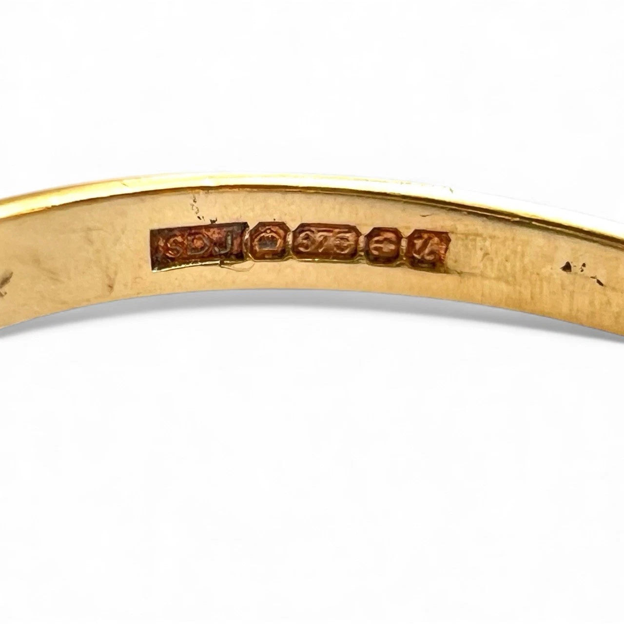 Gold ring with visible hallmark on a white background