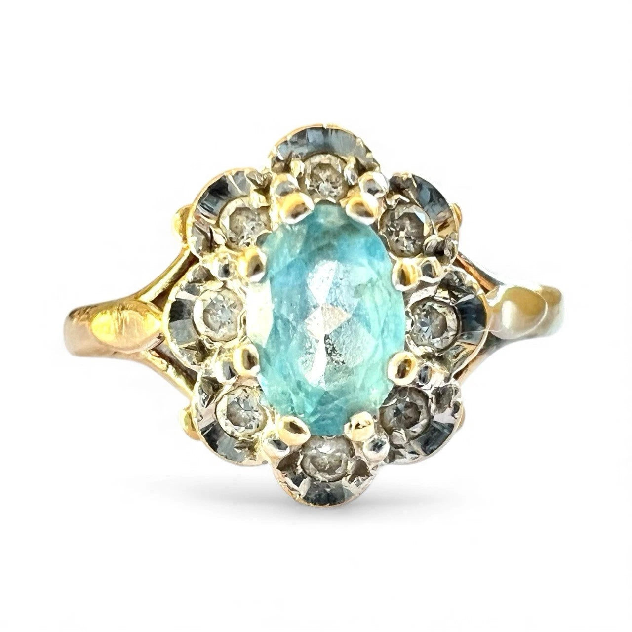 Gold ring with a blue topaz gemstone and smaller diamonds on a white background