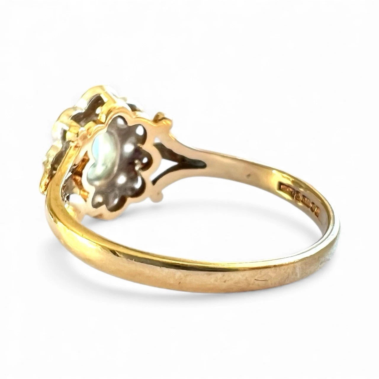 Gold ring with a central gemstone on a white background