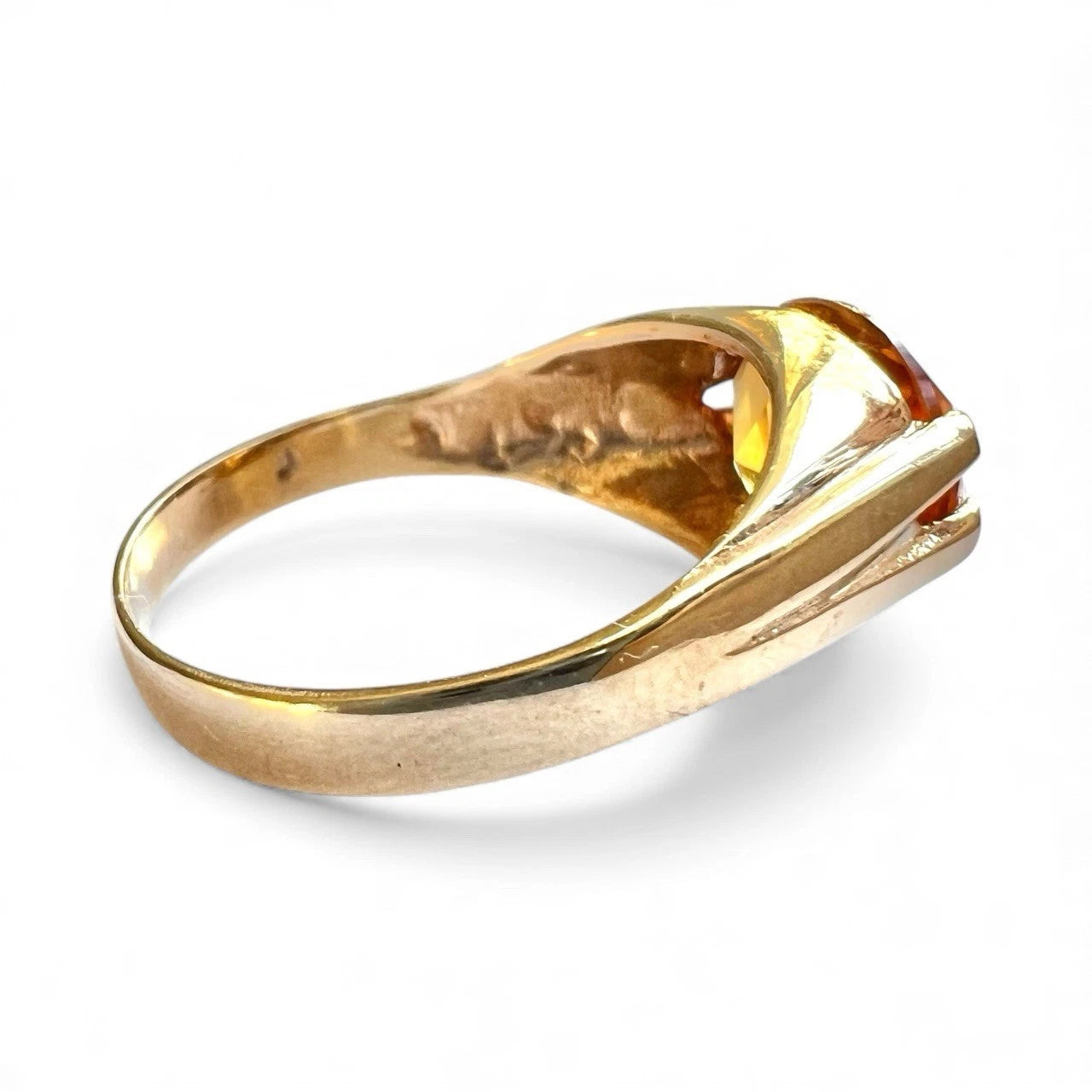 Gold ring with a citrine gemstone on a white background side view 