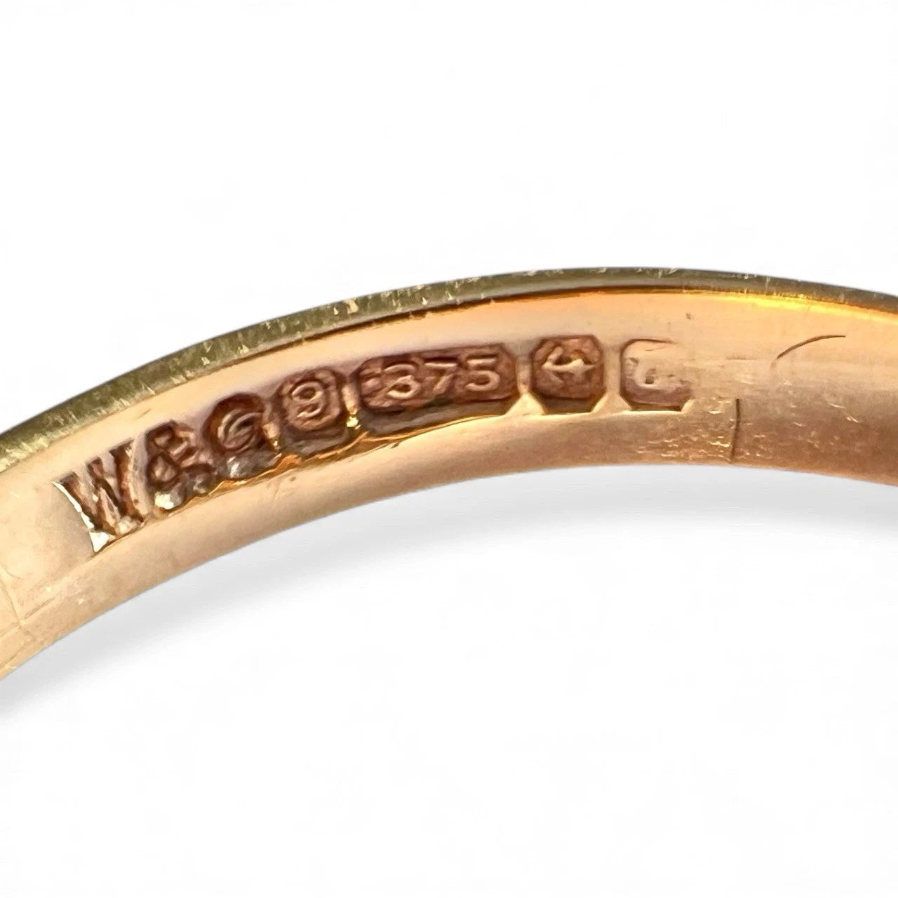 Gold ring with visible hallmarking on a white background