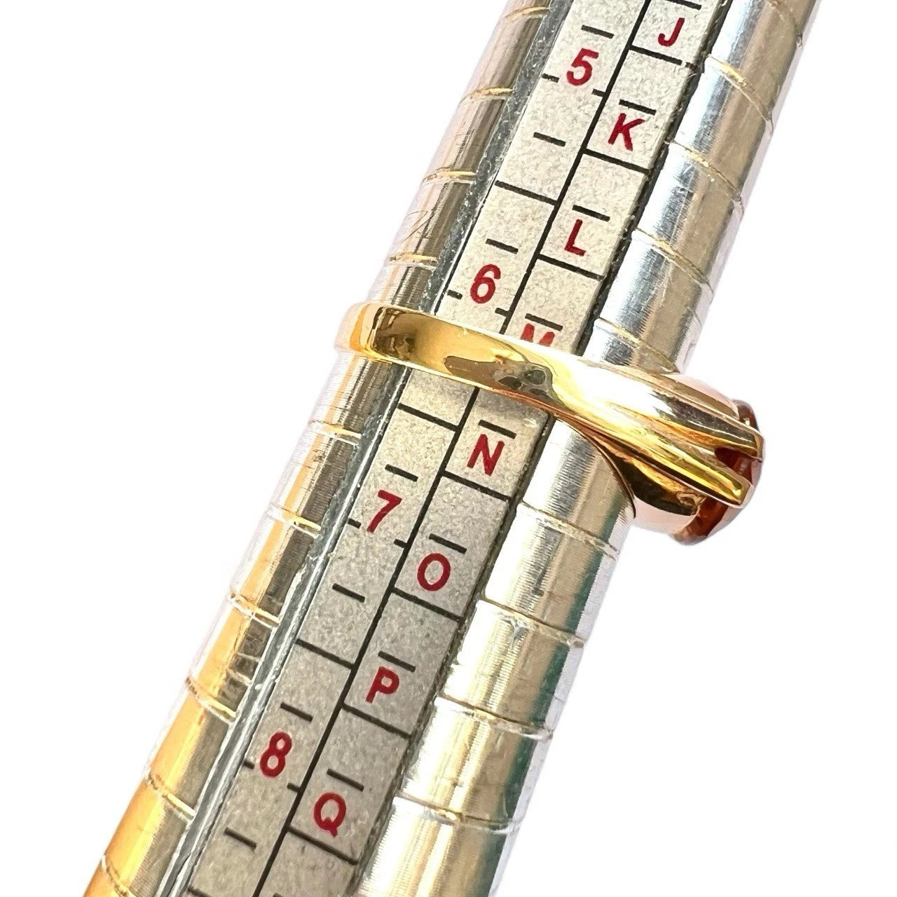 Gold ring displayed on silver measuring tool 