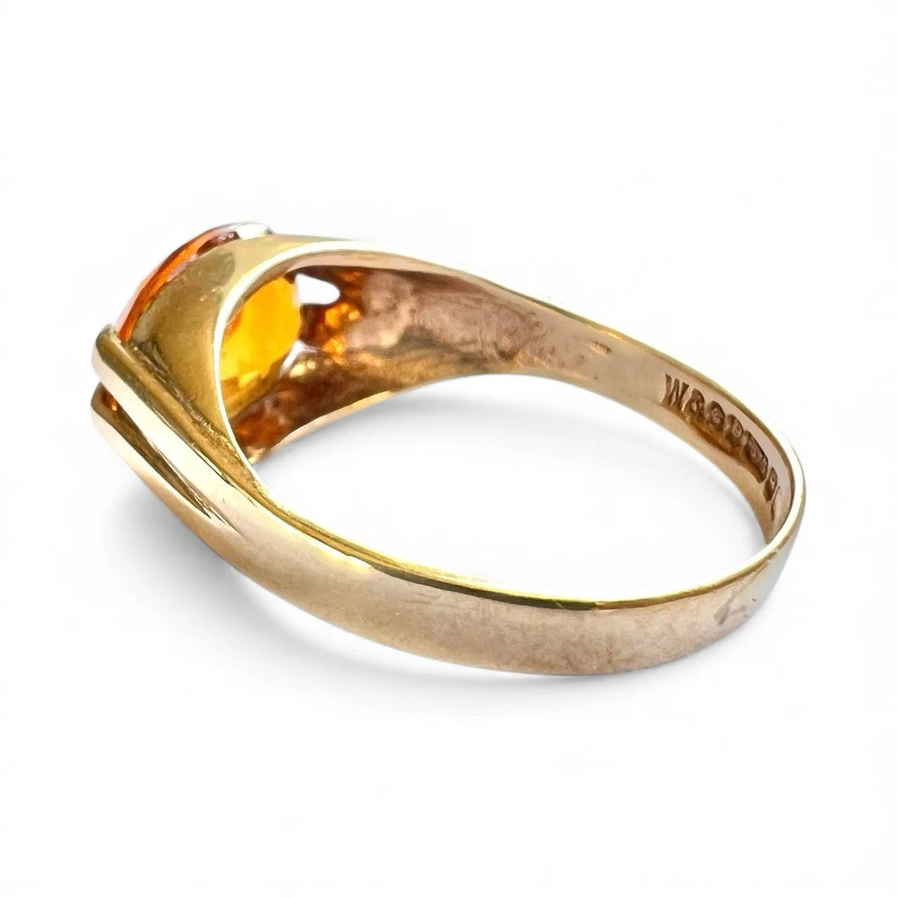 Gold ring with a gemstone rear view with hallmark visible on a white background 