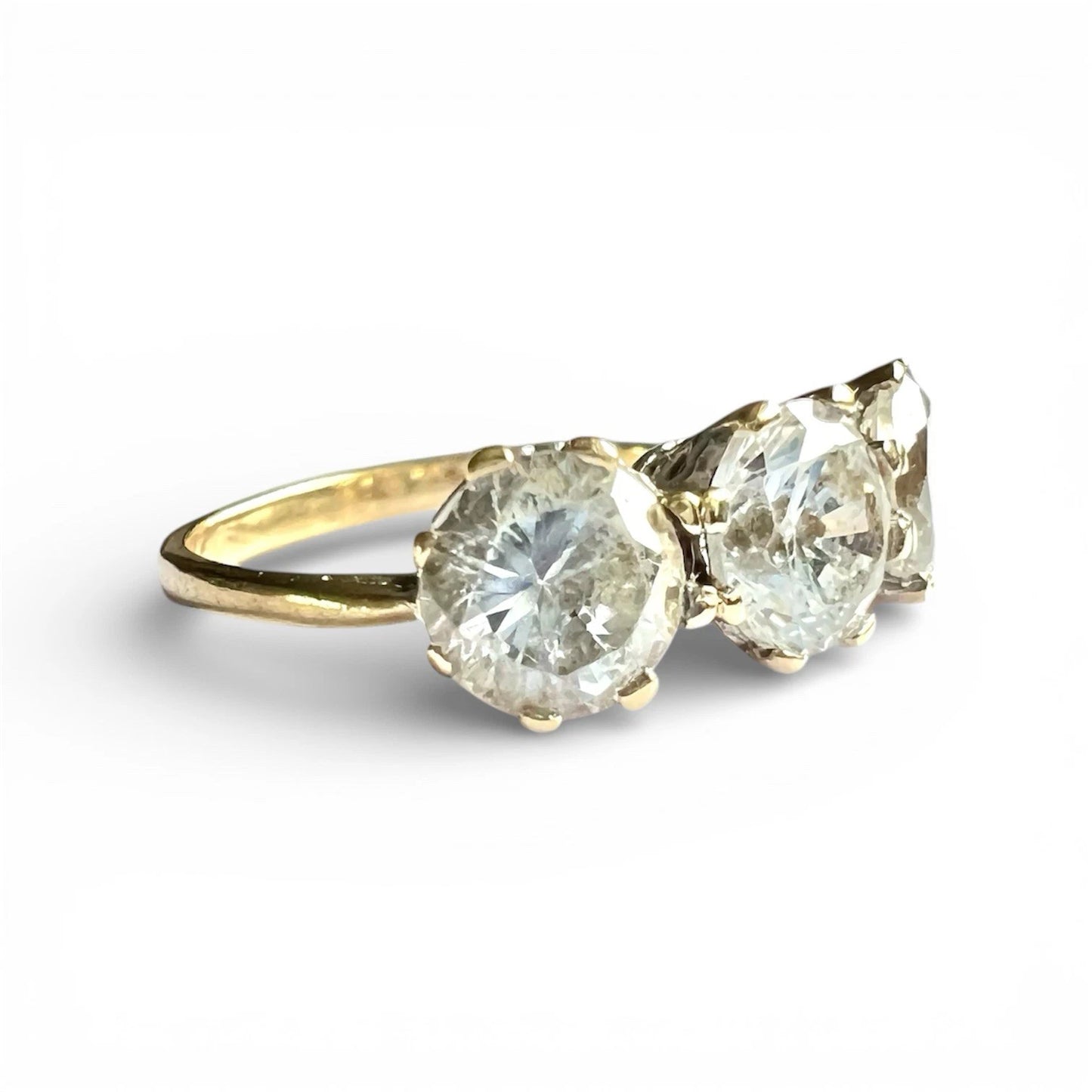 Close up view gold ring with three large CZ on a white background