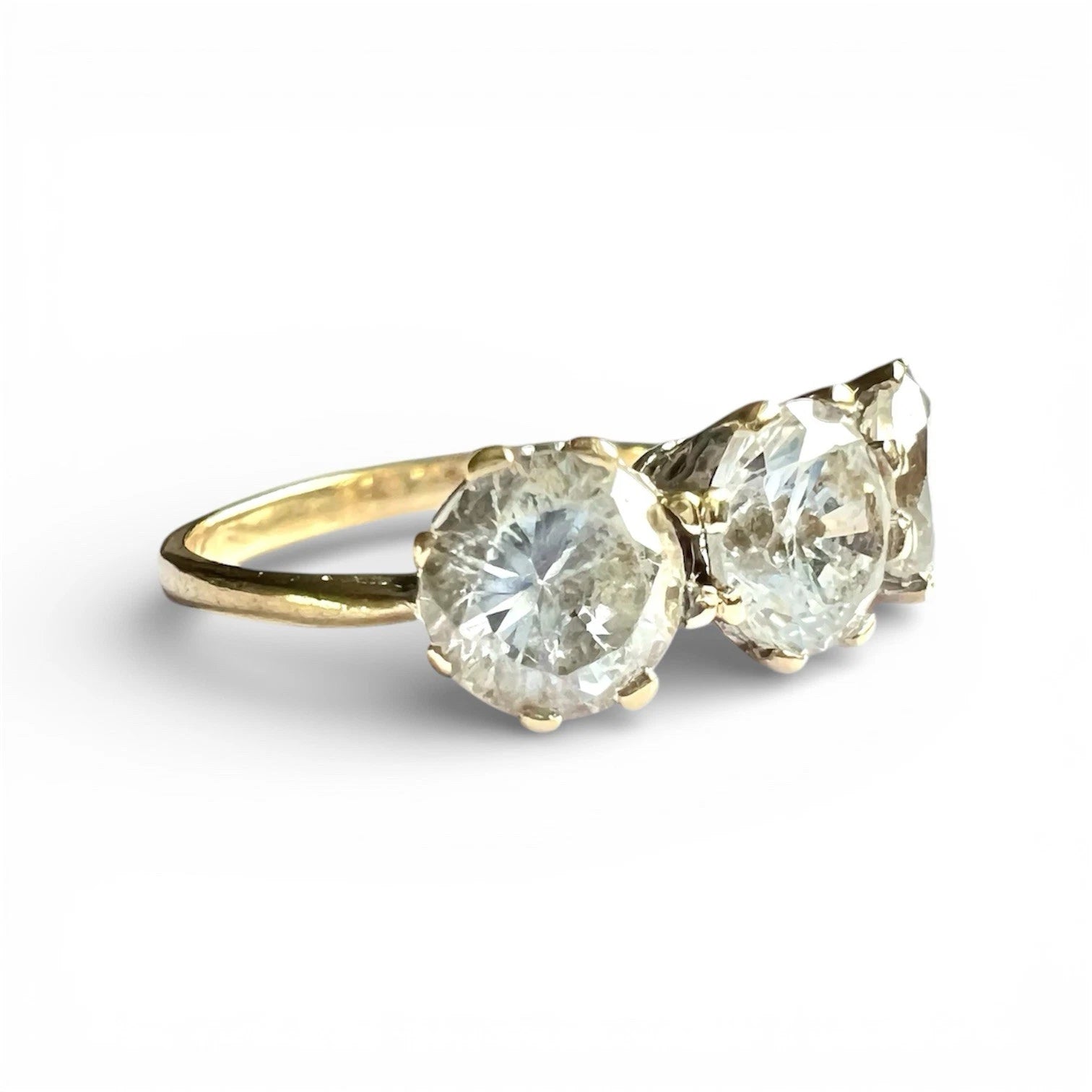 Close up view gold ring with three large CZ on a white background