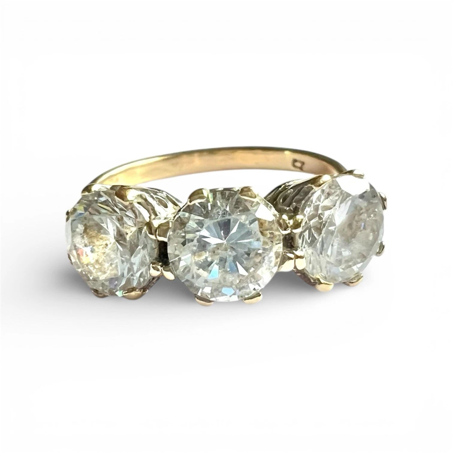 Gold ring with three large CZ on a white background