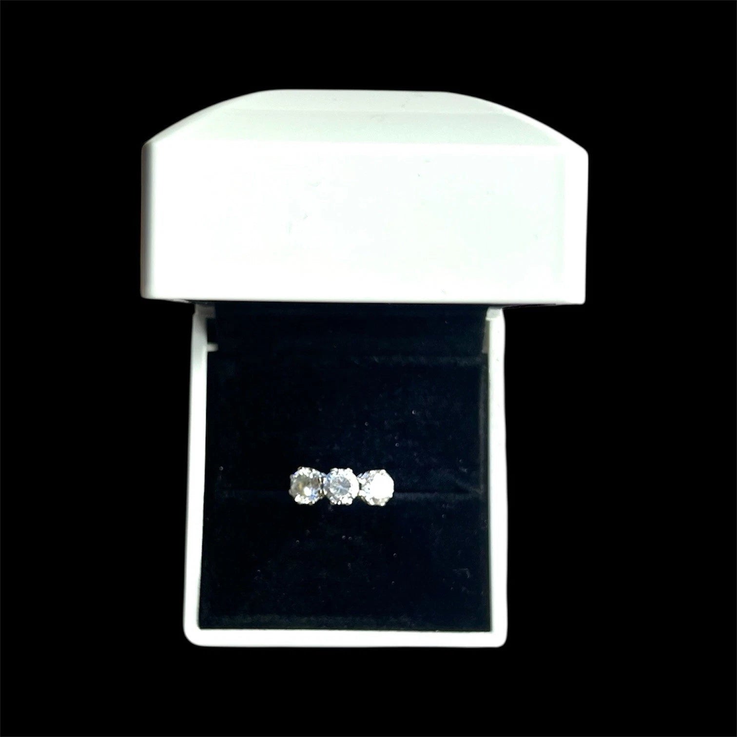 Three stone CZ ring in a white box on a black background
