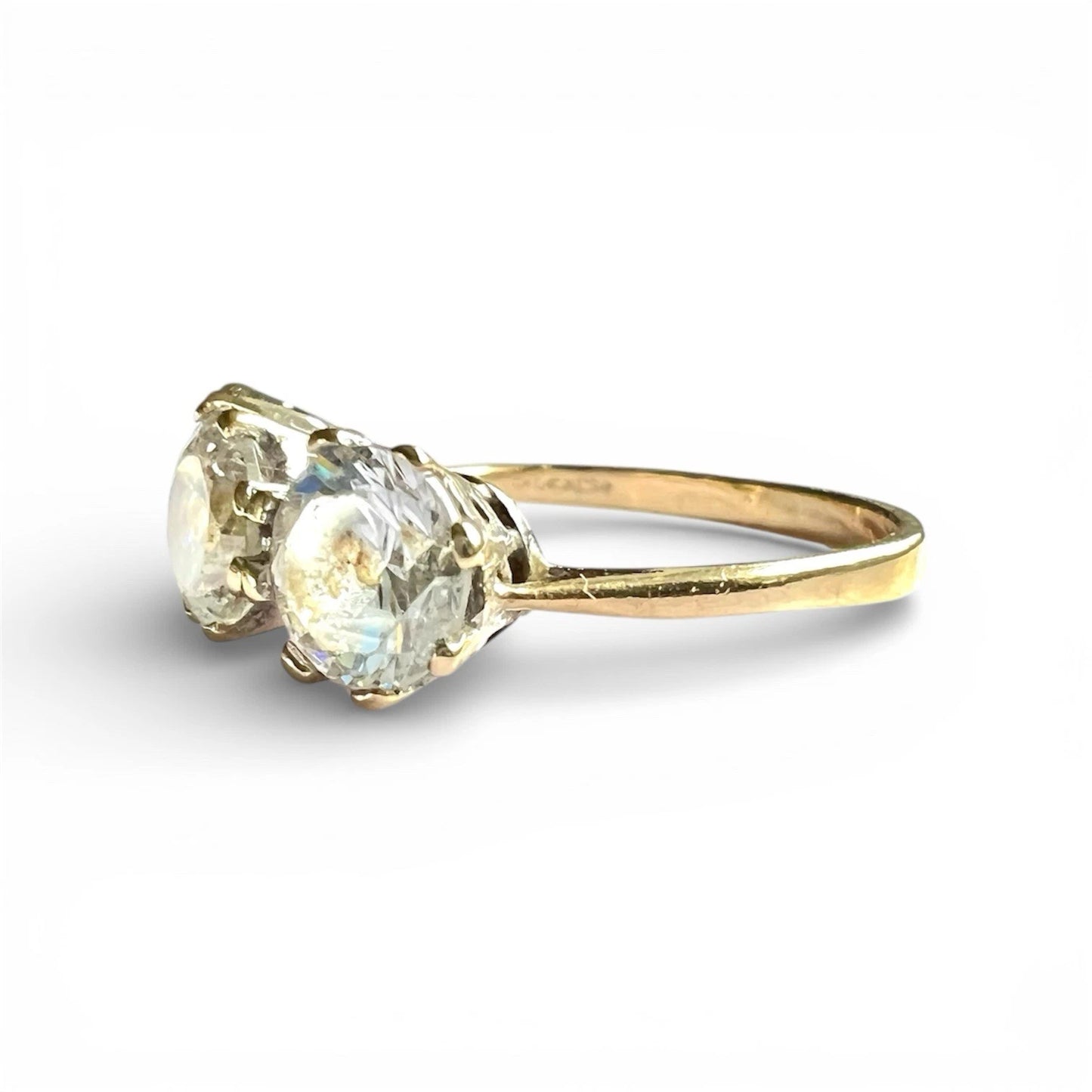 Gold ring with three cz gemstones on a white background
