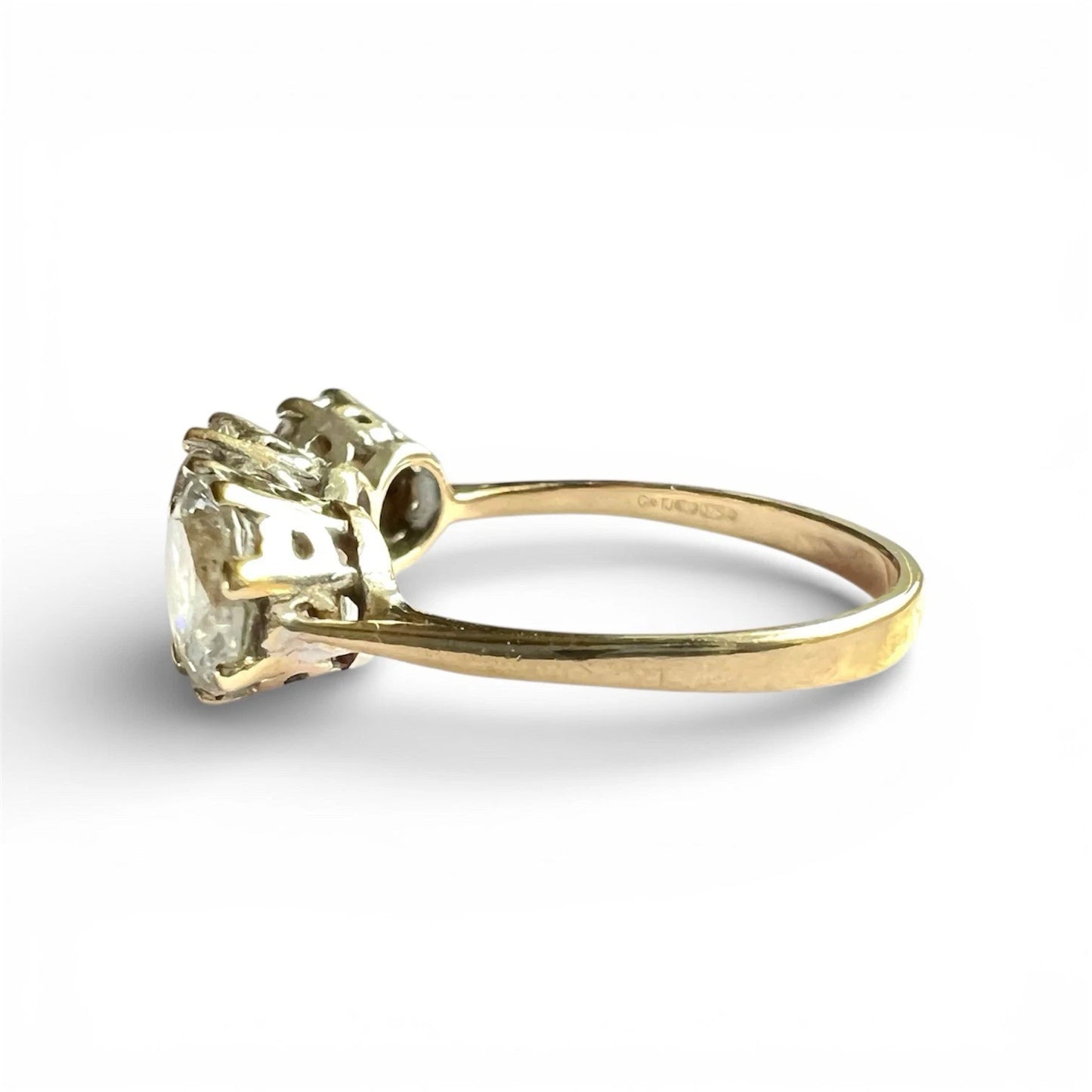 Close up gold ring with three CZ gemstones on a white background