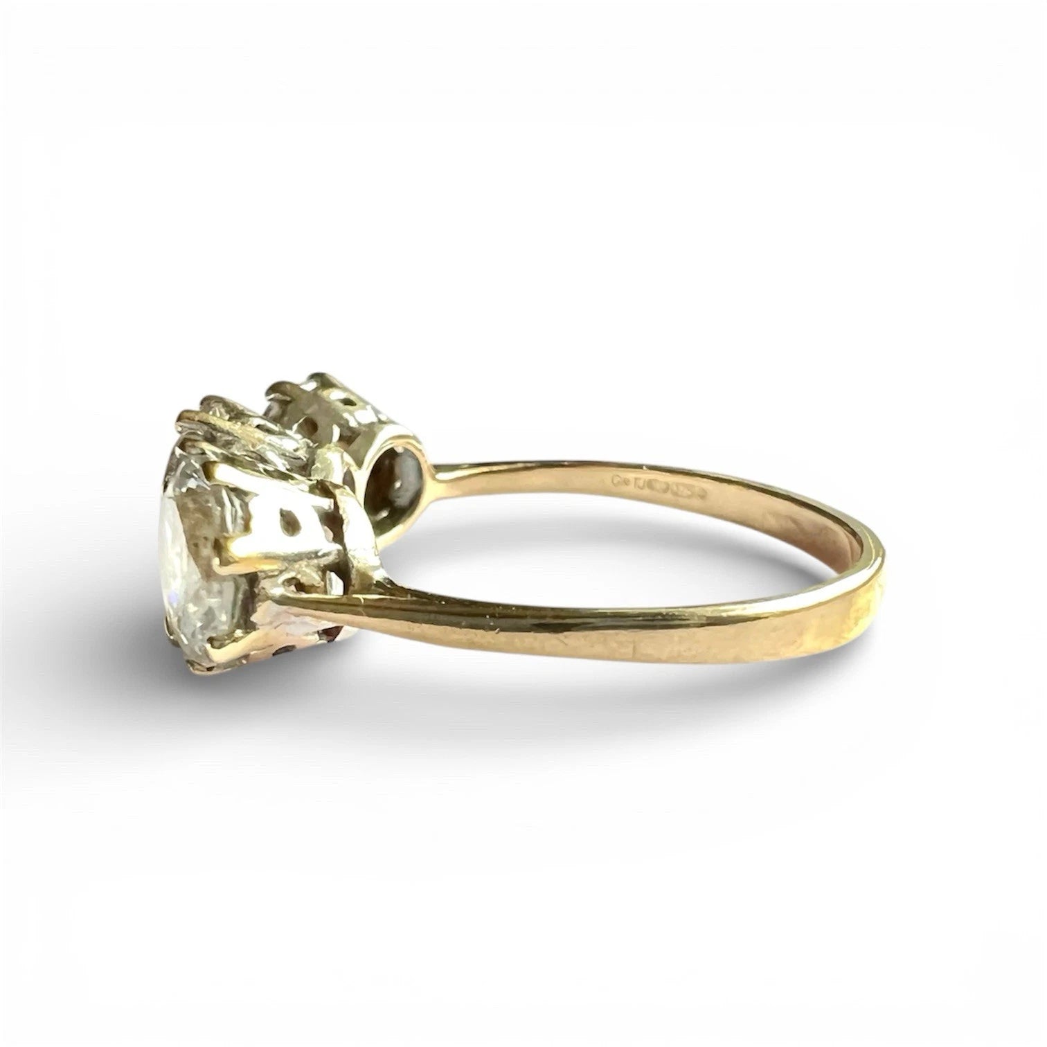 Close up gold ring with three CZ gemstones on a white background