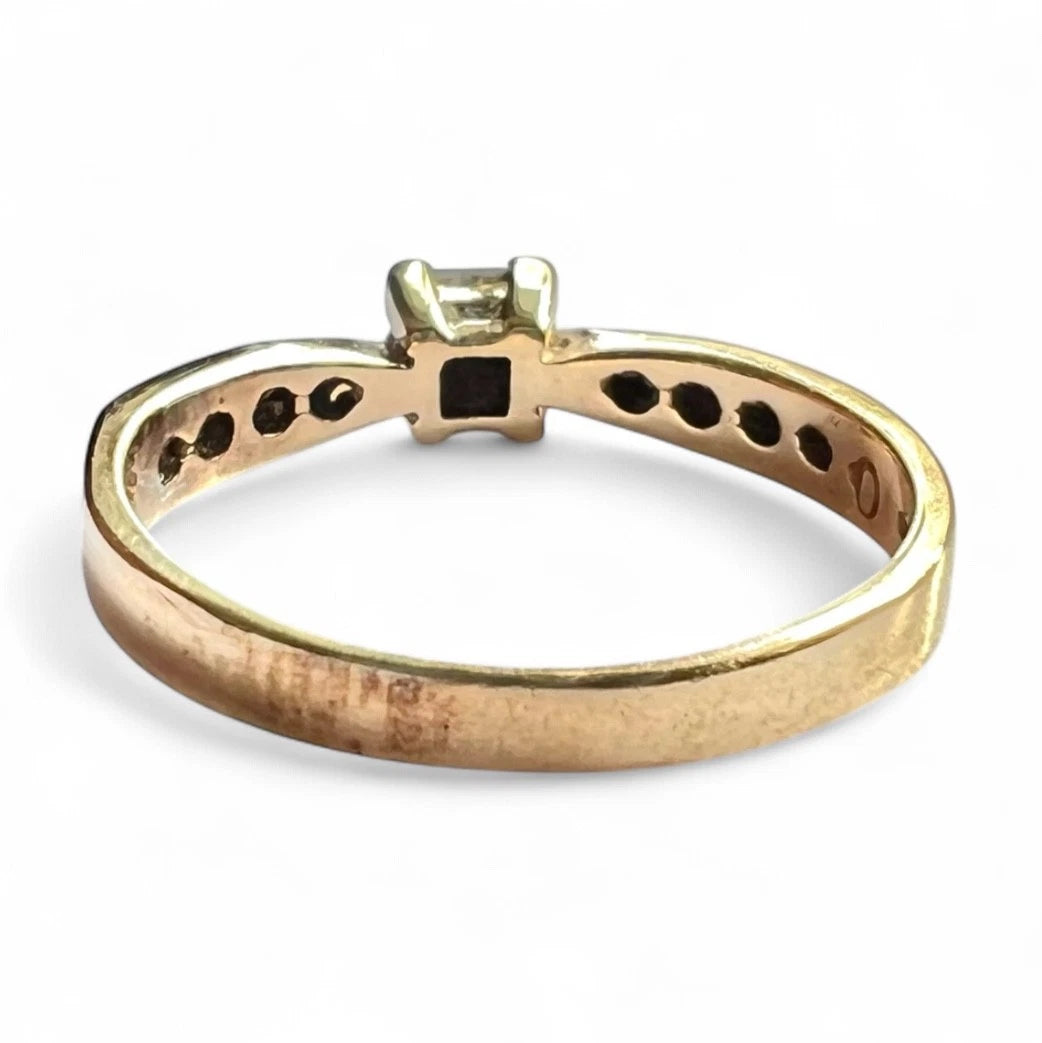 Gold ring with CZ on a white background, close rear view of setting and gold band 
