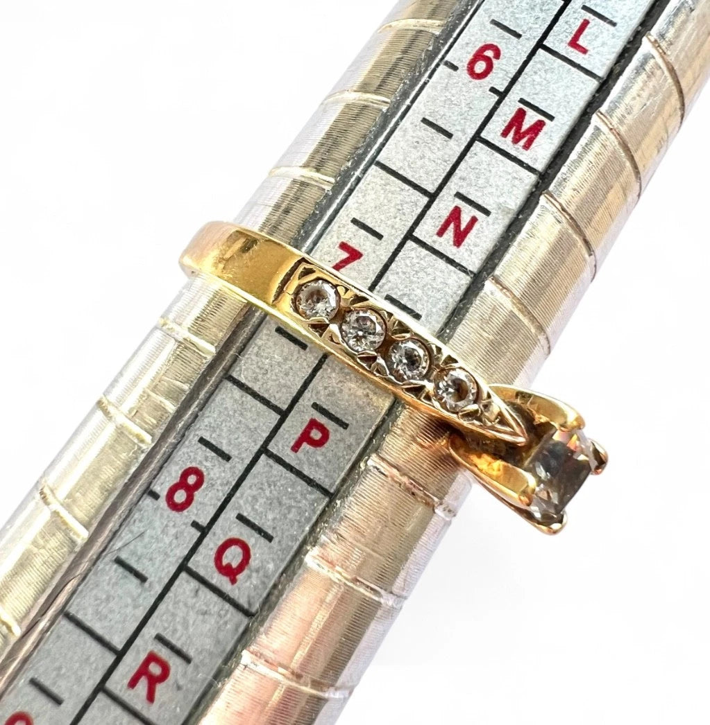 Gold ring with cubic zirconia on a ring size gauge