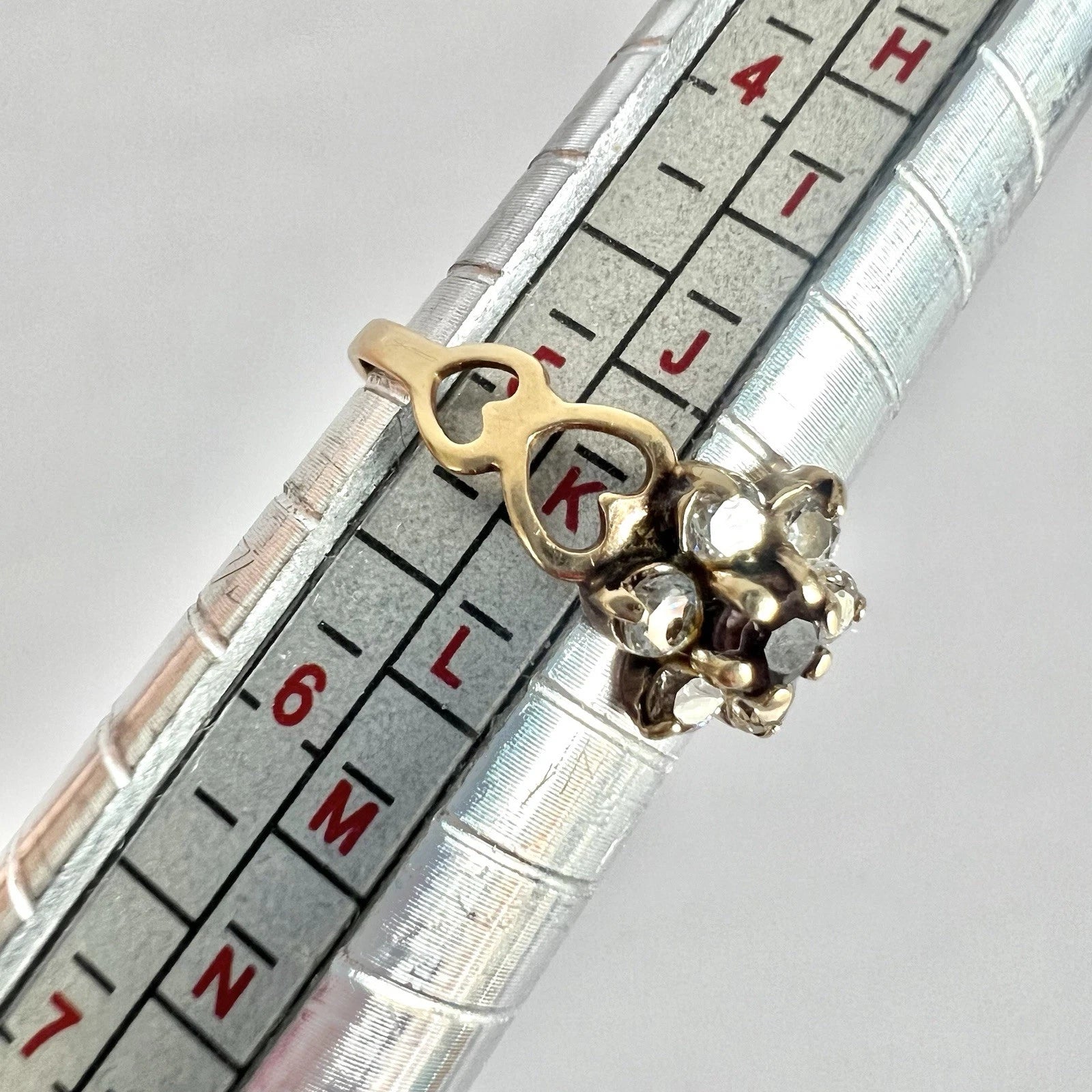 Gold ring with cubic zirconia on a ruler for size reference