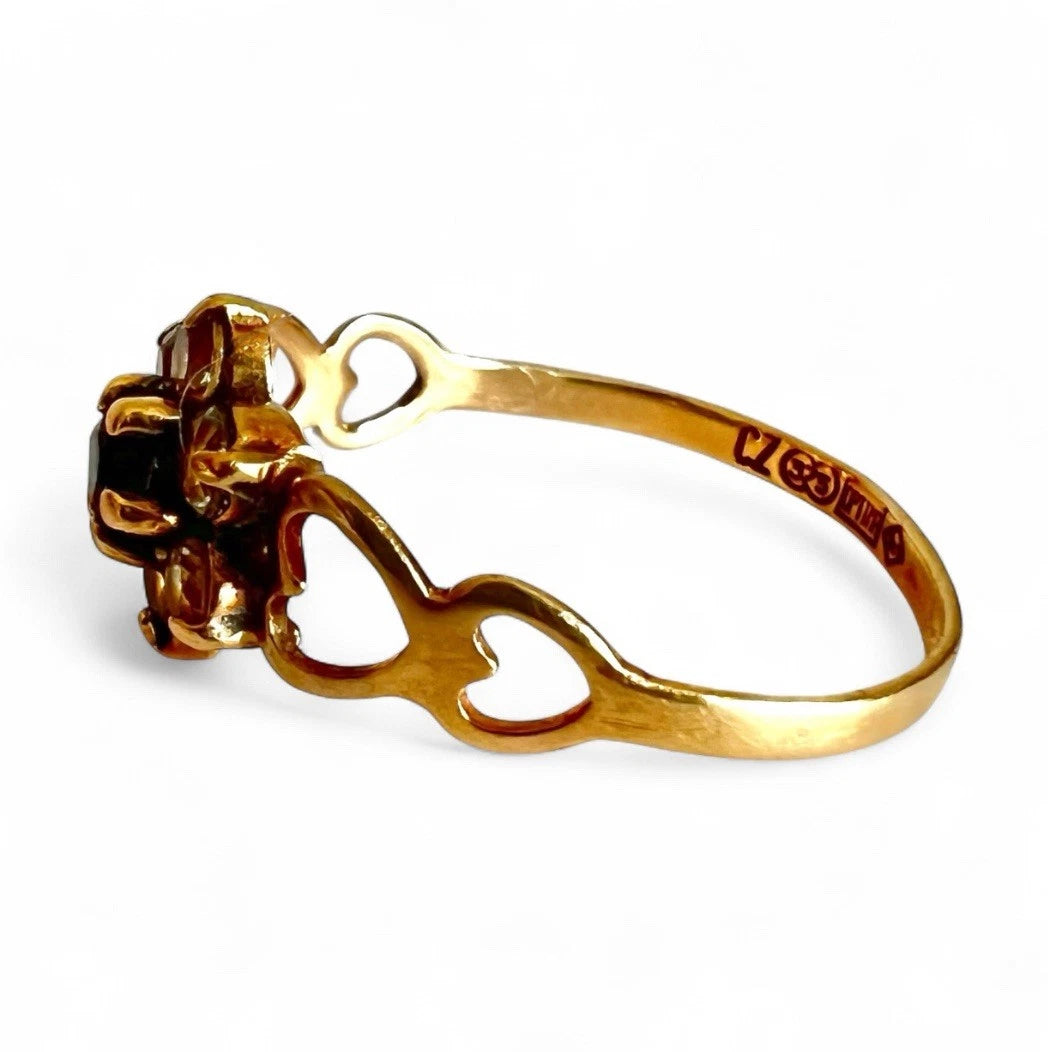 Gold ring with a heart design on a white background