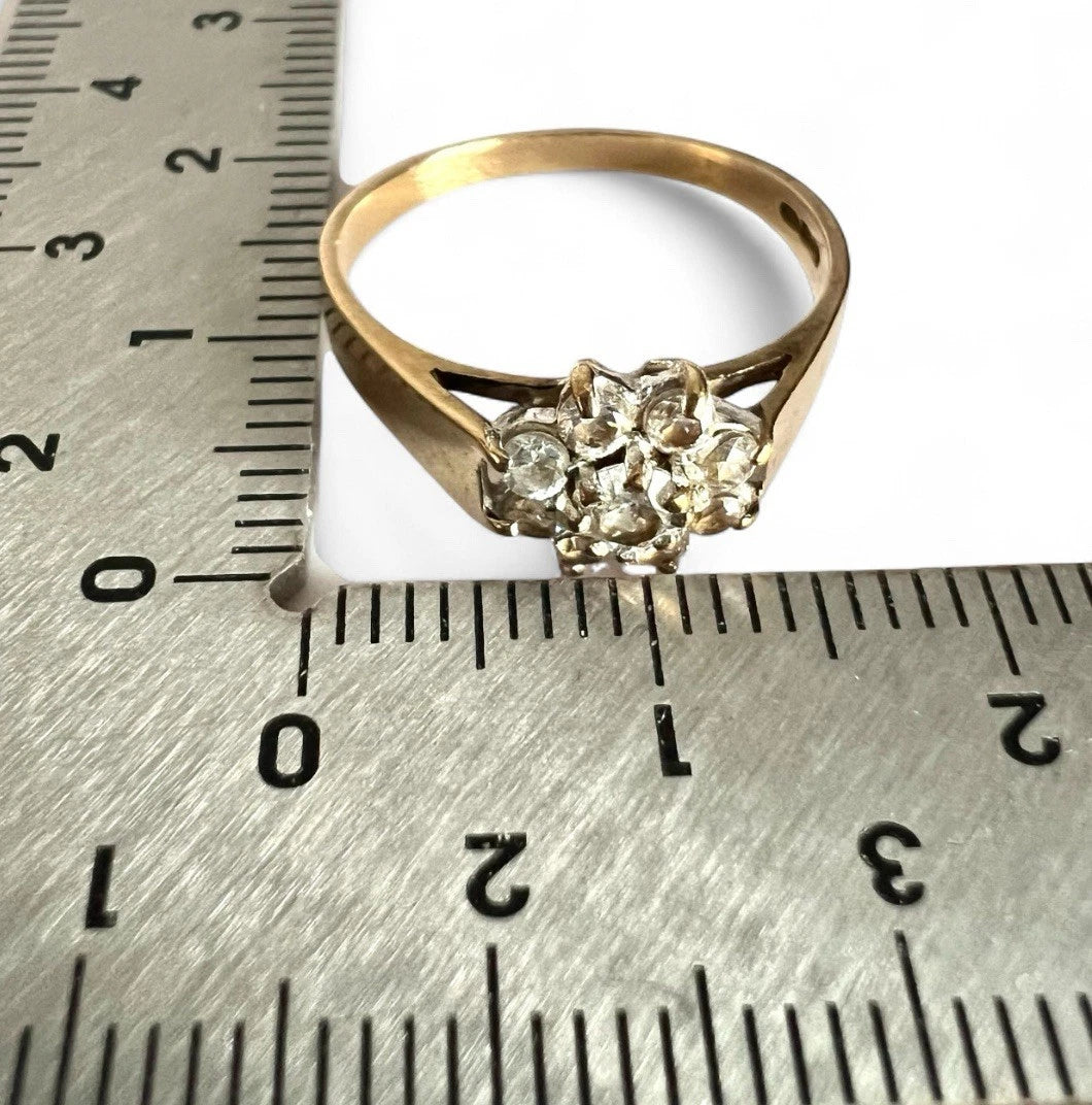 Gold ring with cubic zirconia on a metal ruler for size reference