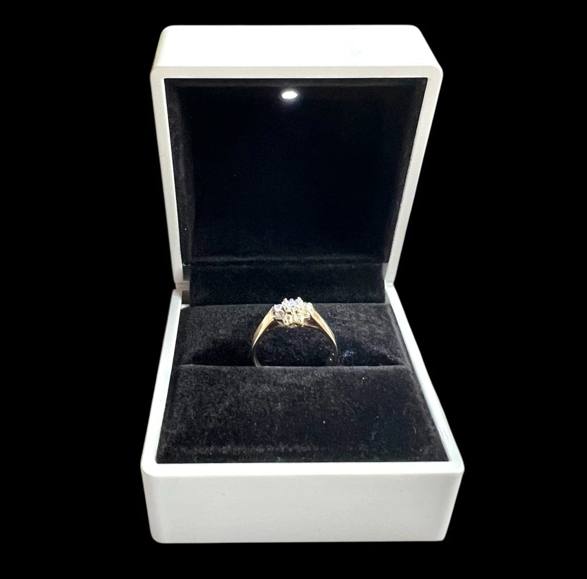 Gold ring in a white jewellery box with a black interior