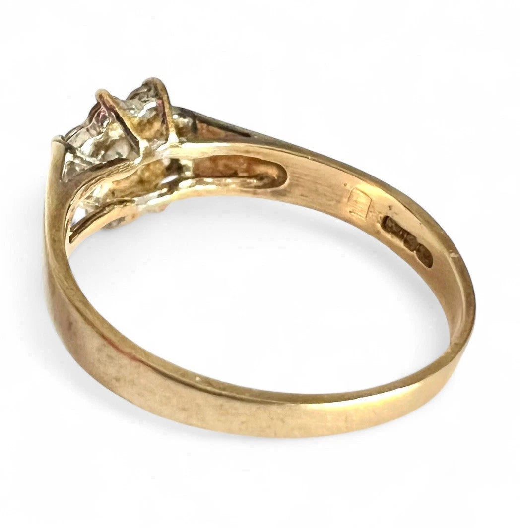 Gold ring with a cubic zirconia on a white background, close up rear view of gold band 