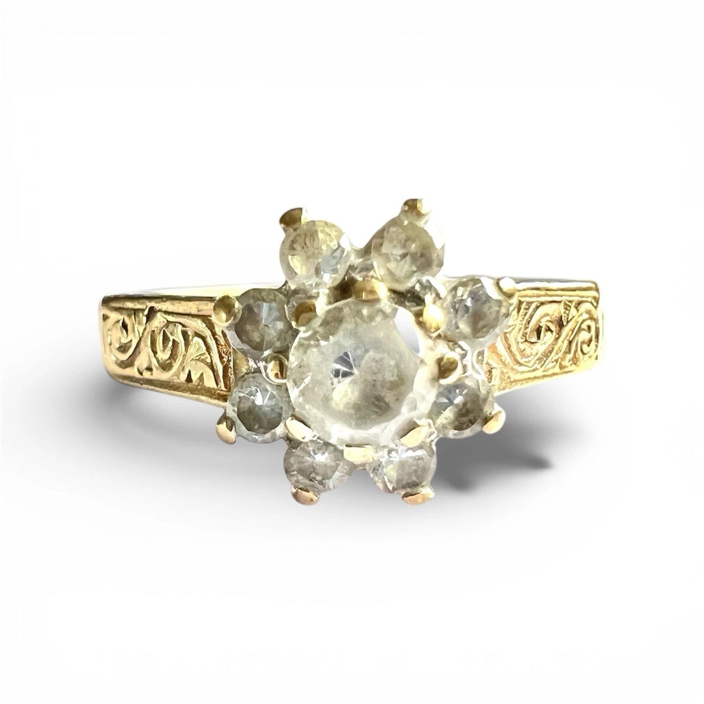 Gold ring with decorative band and central gemstone on a white background