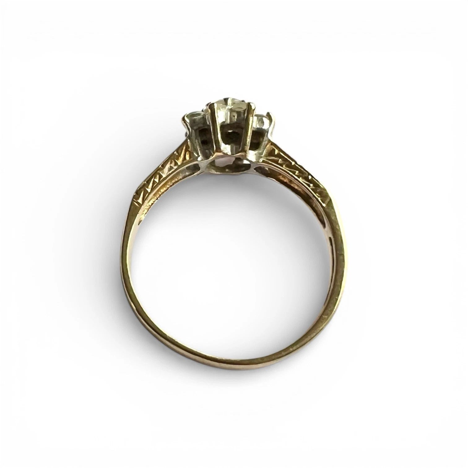 Gold ring with a central gemstone on a white background top down view 