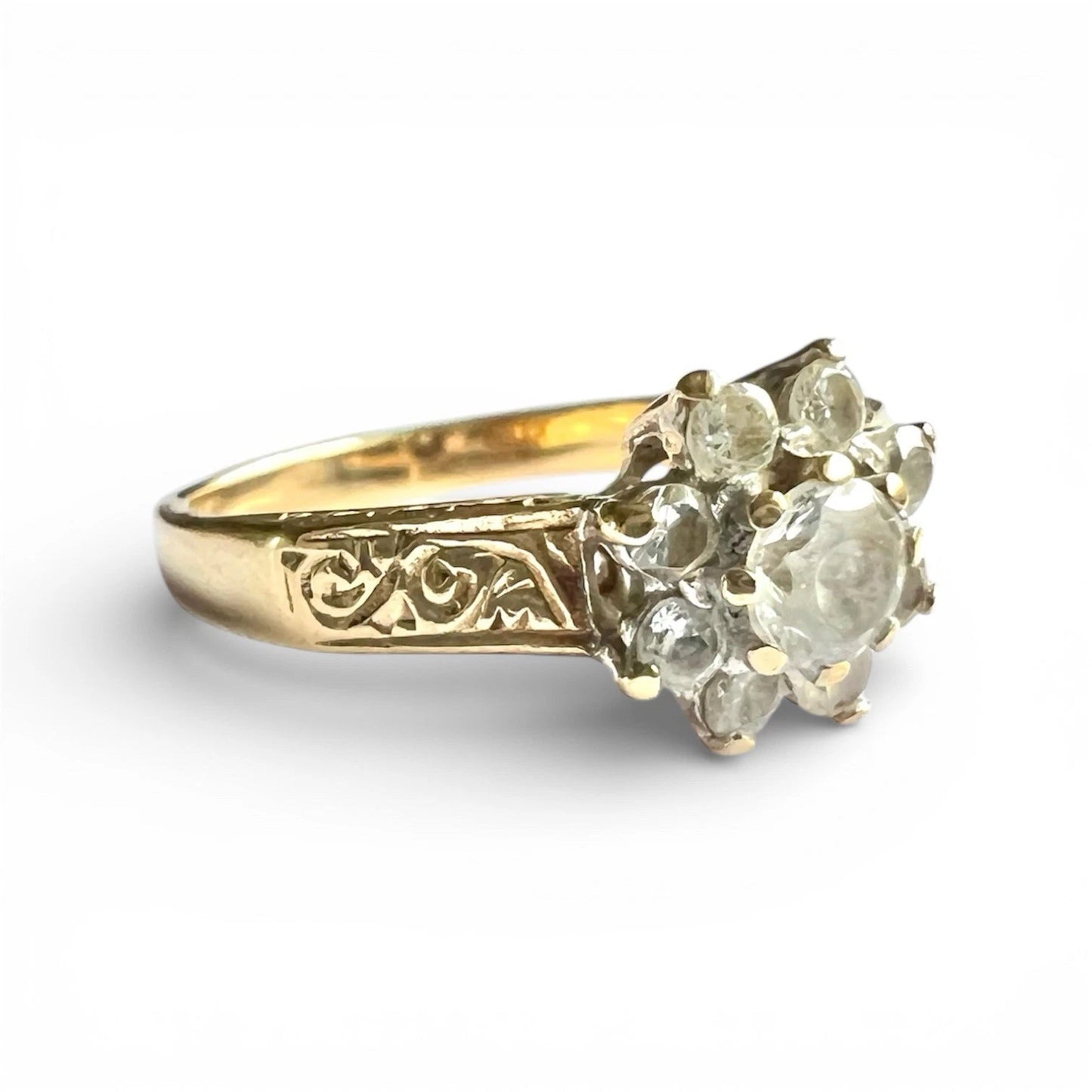 Gold ring with diamond-like stones on a white background