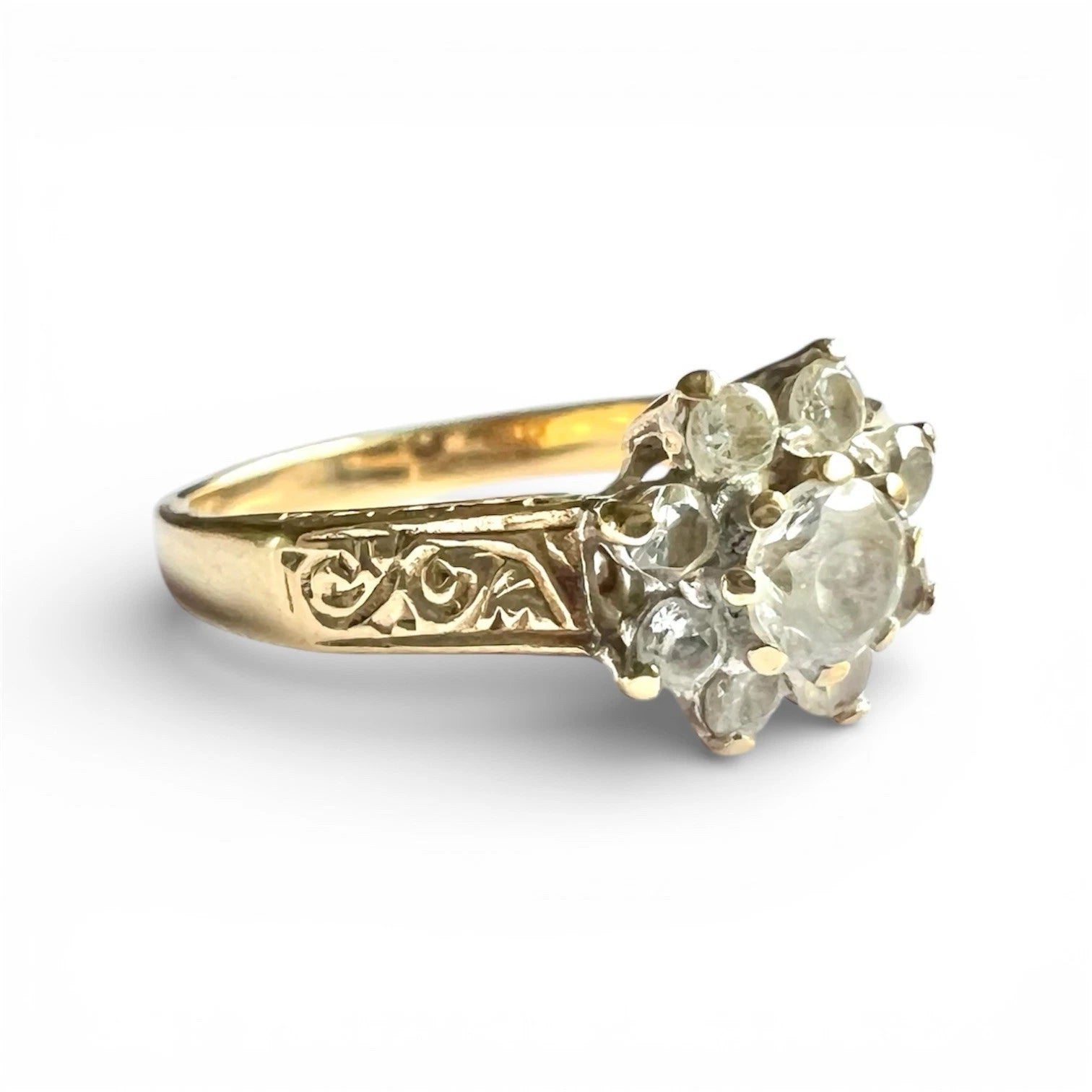 Gold ring with diamond-like stones on a white background