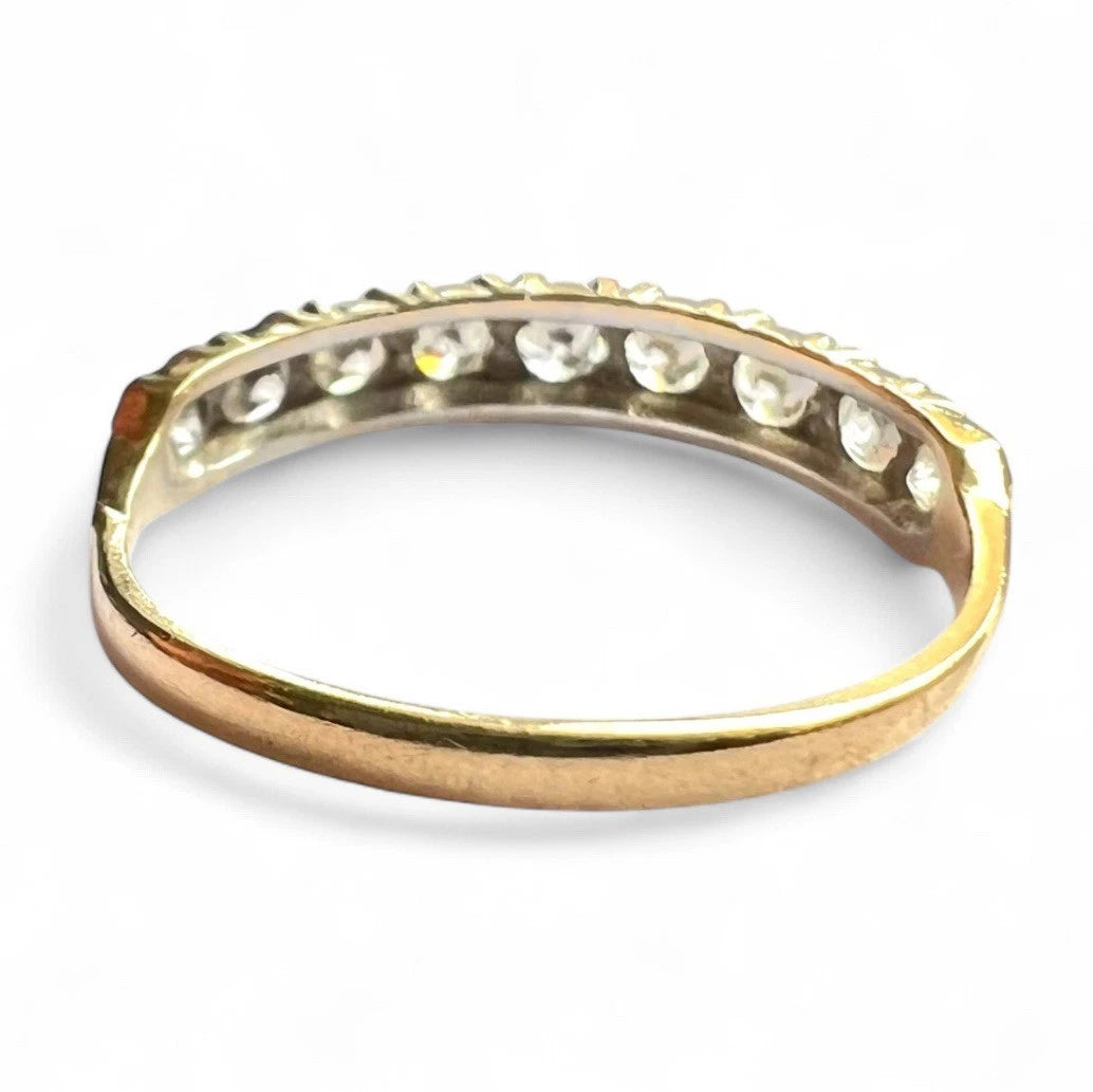 Gold ring with embedded cubic zirconia on a white background