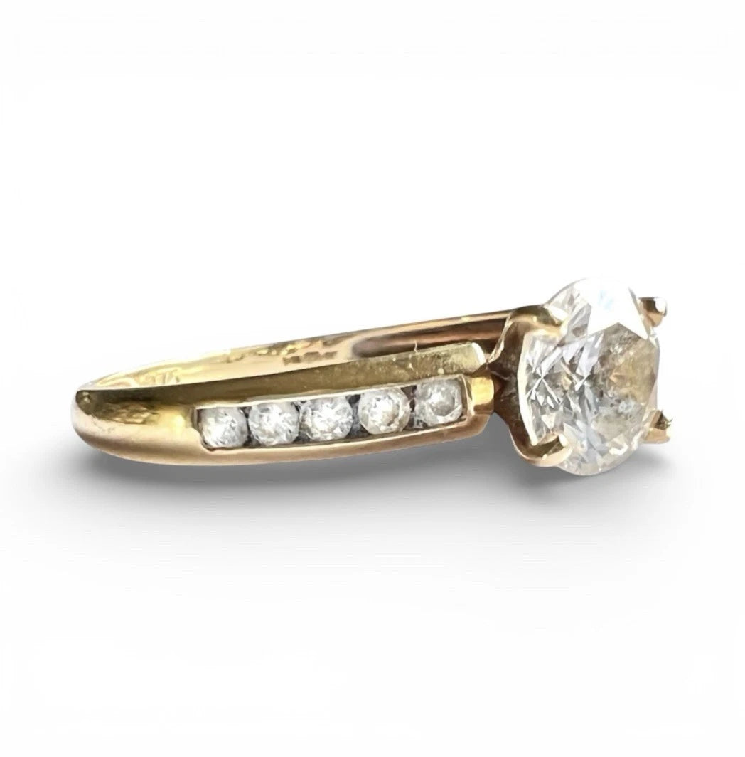 Gold ring with a large CZ and smaller CZ on a white background