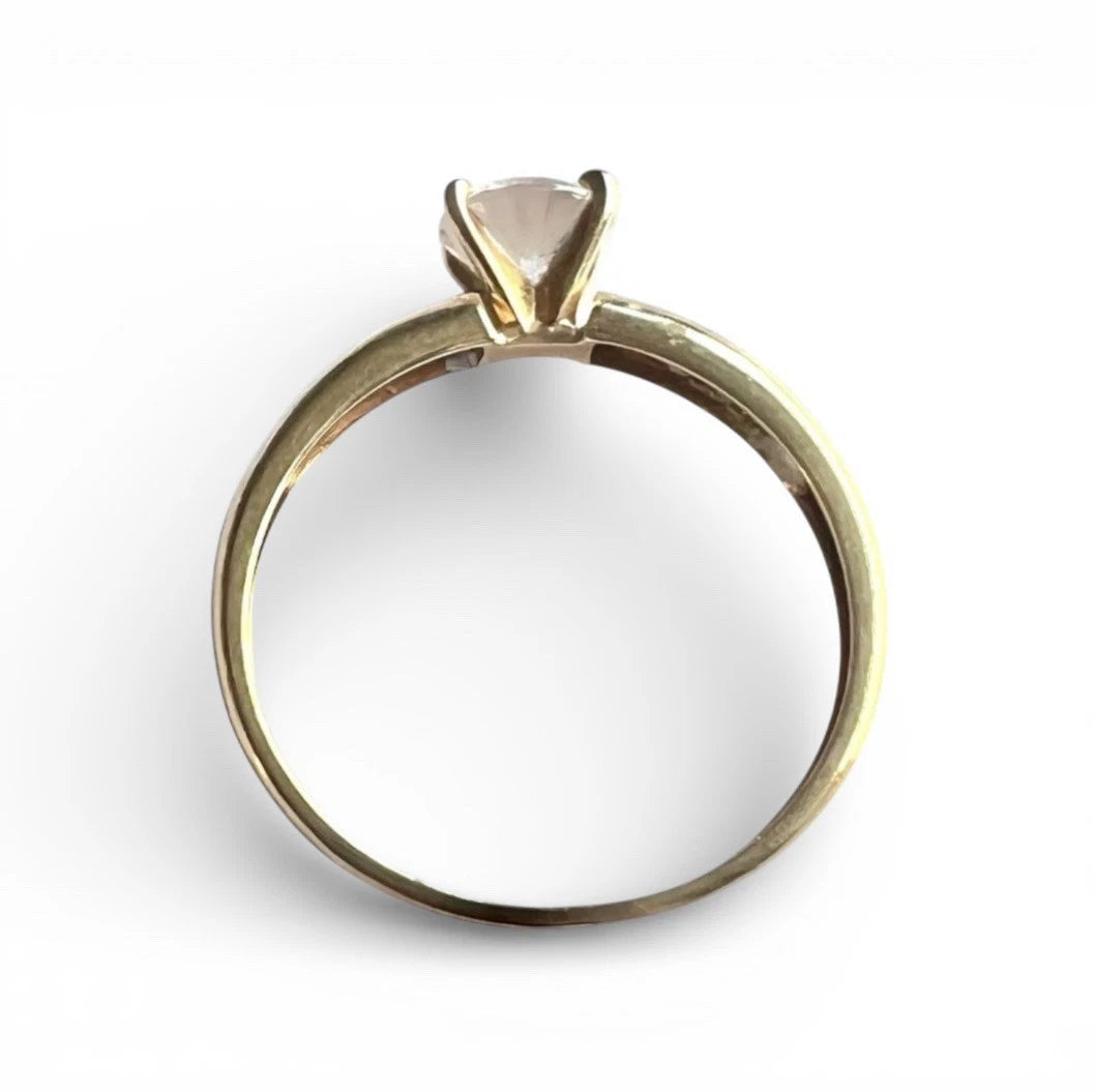 Gold ring with a large CZ gemstone on a white background