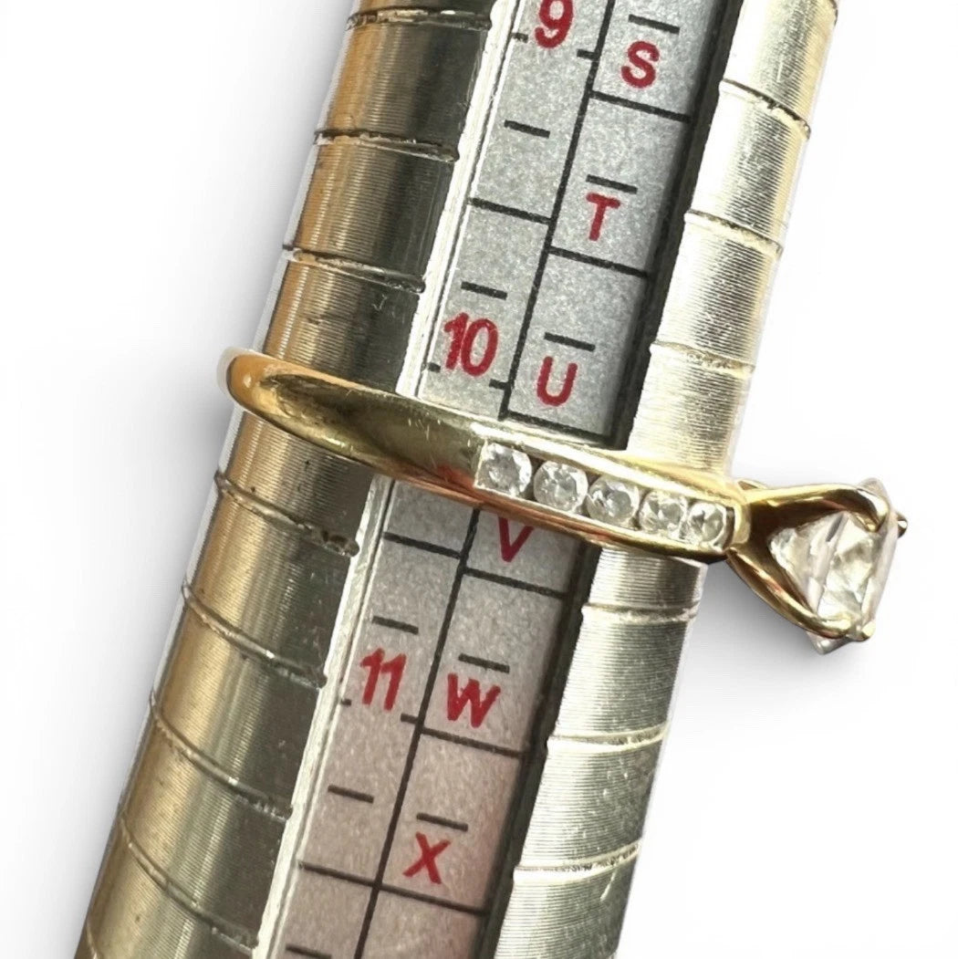 Gold ring with CZ on a ruler for size reference