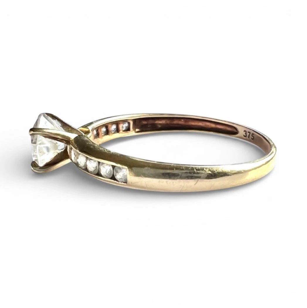 Close up side view Gold ring with a CZ on a white background