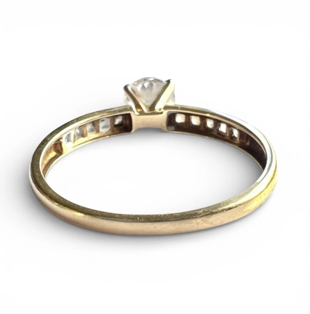 Gold ring with a large CZ on a white background. Rear view of setting and gold band 