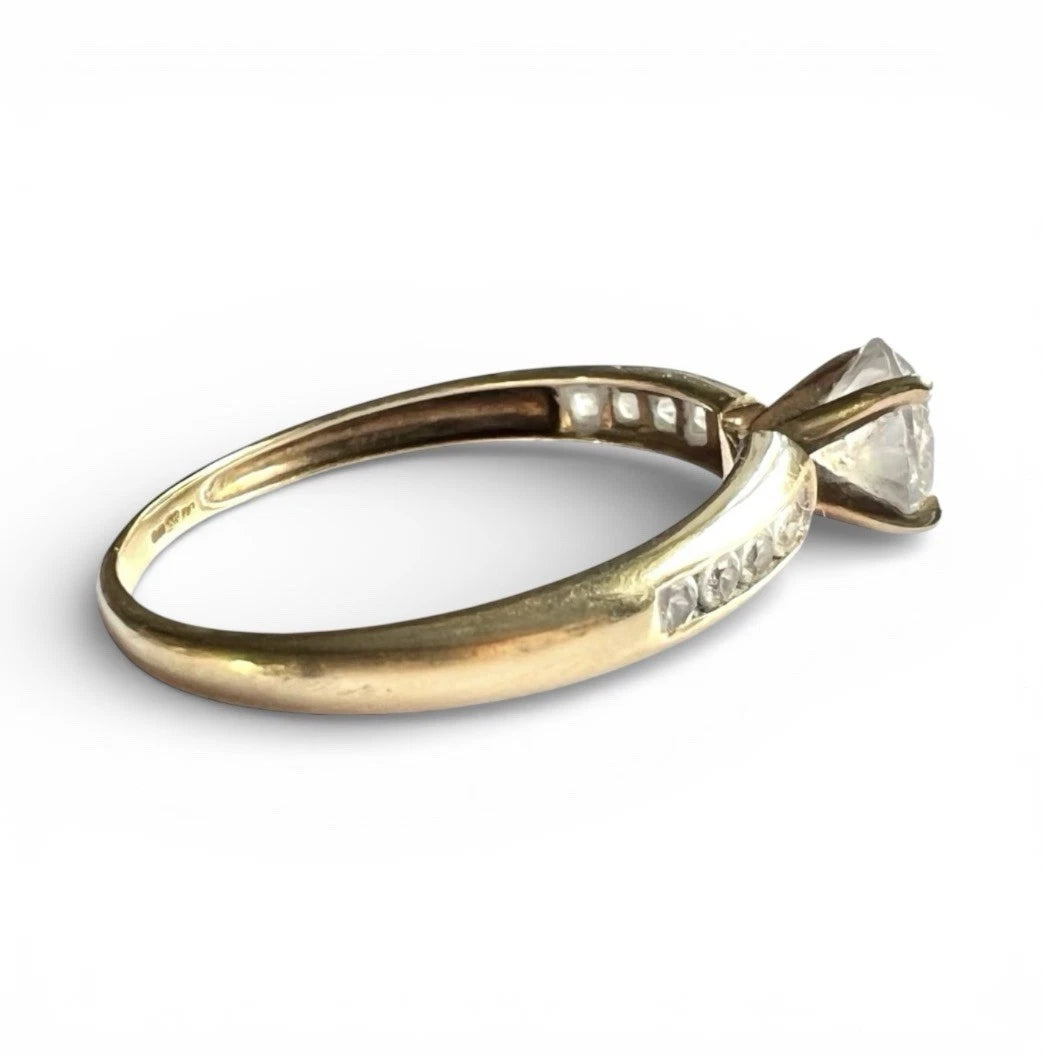 Gold ring with a CZ on a white background. Close up side view 